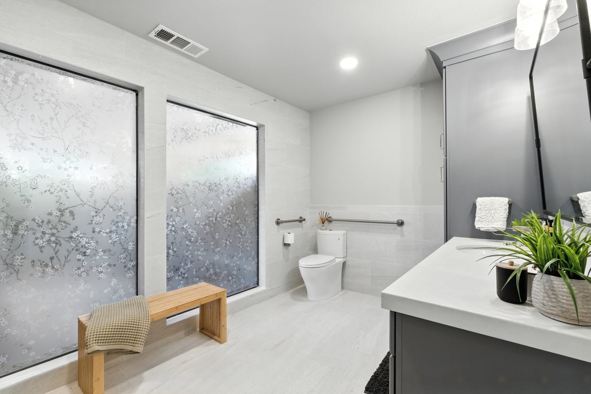 Kerman bathroom remodel with floral frosted privacy windows, seating, and space with universal design elements