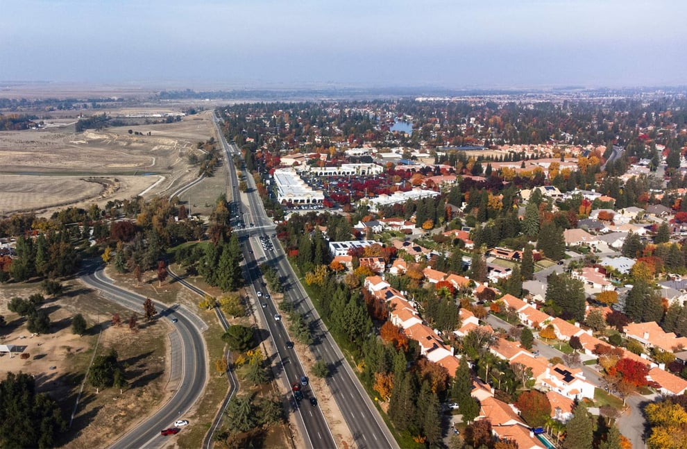Aerial view of Fresno, CA showing residential neighborhood, main road, and surrounding fields