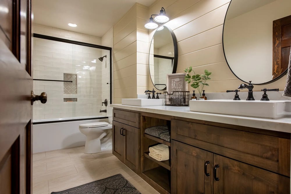 Double vanity with black fixtures and vessel sinks in Fresno, CA bathroom by Imagine Remodeling