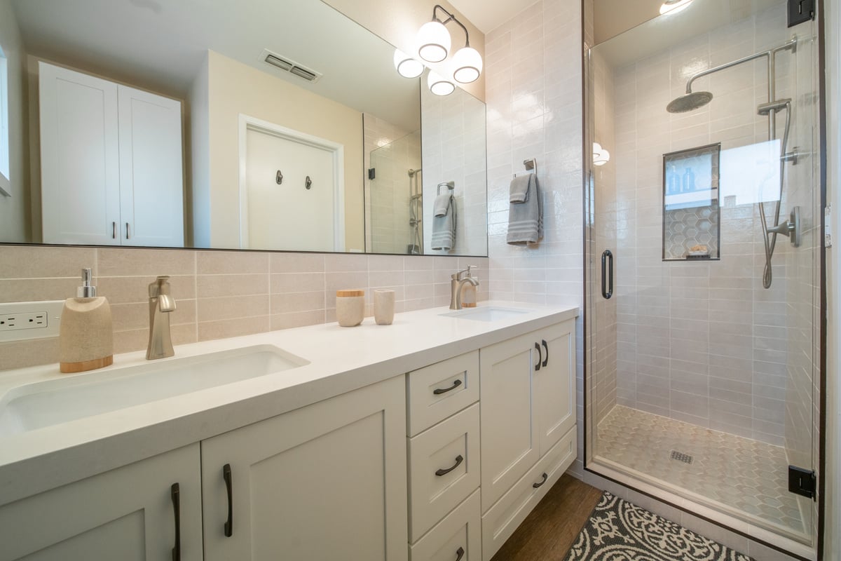 Modern Fresno, CA bathroom with double vanity, light tile shower, and sleek fixtures