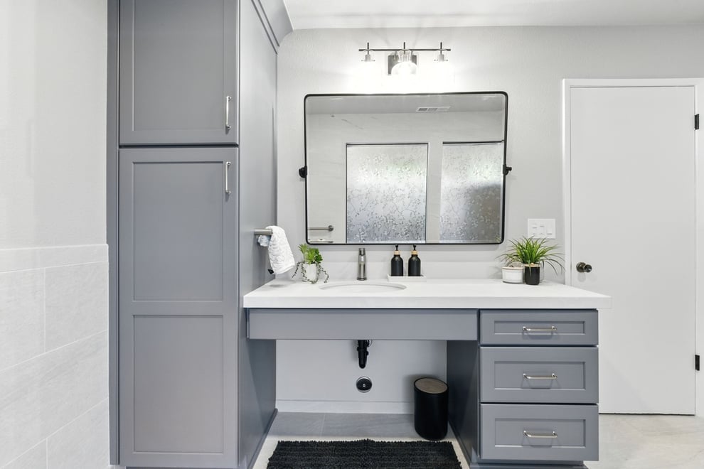 Accessible bathroom vanity with gray cabinets and large mirror in Fresno