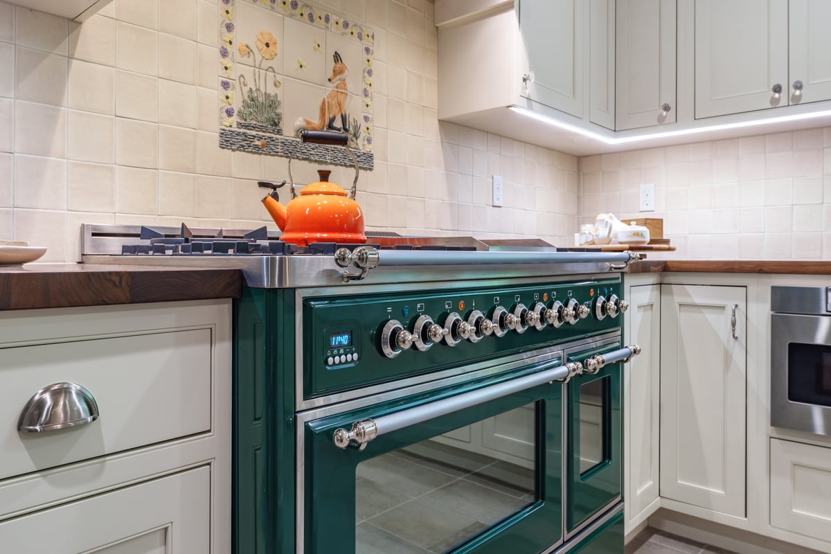 green appliances with white cabinets and wood countertops