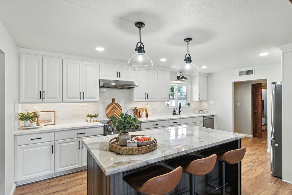 Modern kitchen with large island, pendant lights, and white cabinetry in Clovis, CA