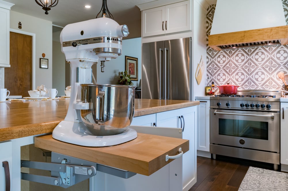 Pull-out mixer stand in island with butcher block countertops by Imagine Remodeling