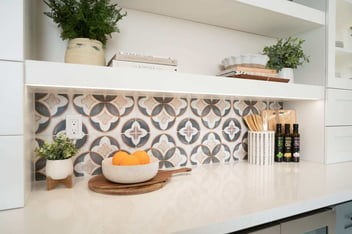 White countertops and mosaic backsplash in Fresno kitchen remodel by Imagine Remodeling