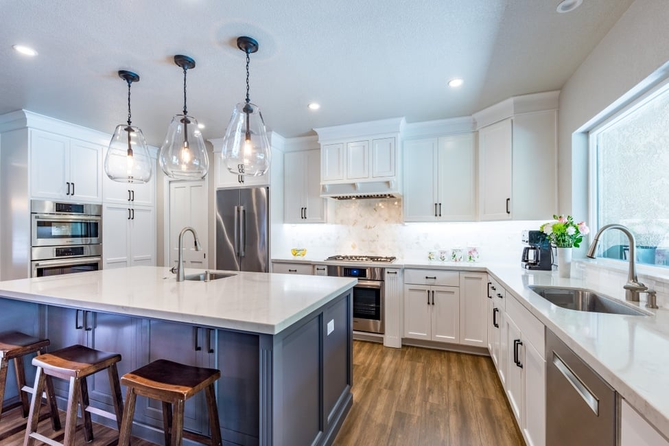 White kitchen remodel in Fresno with blue island and pendant lights
