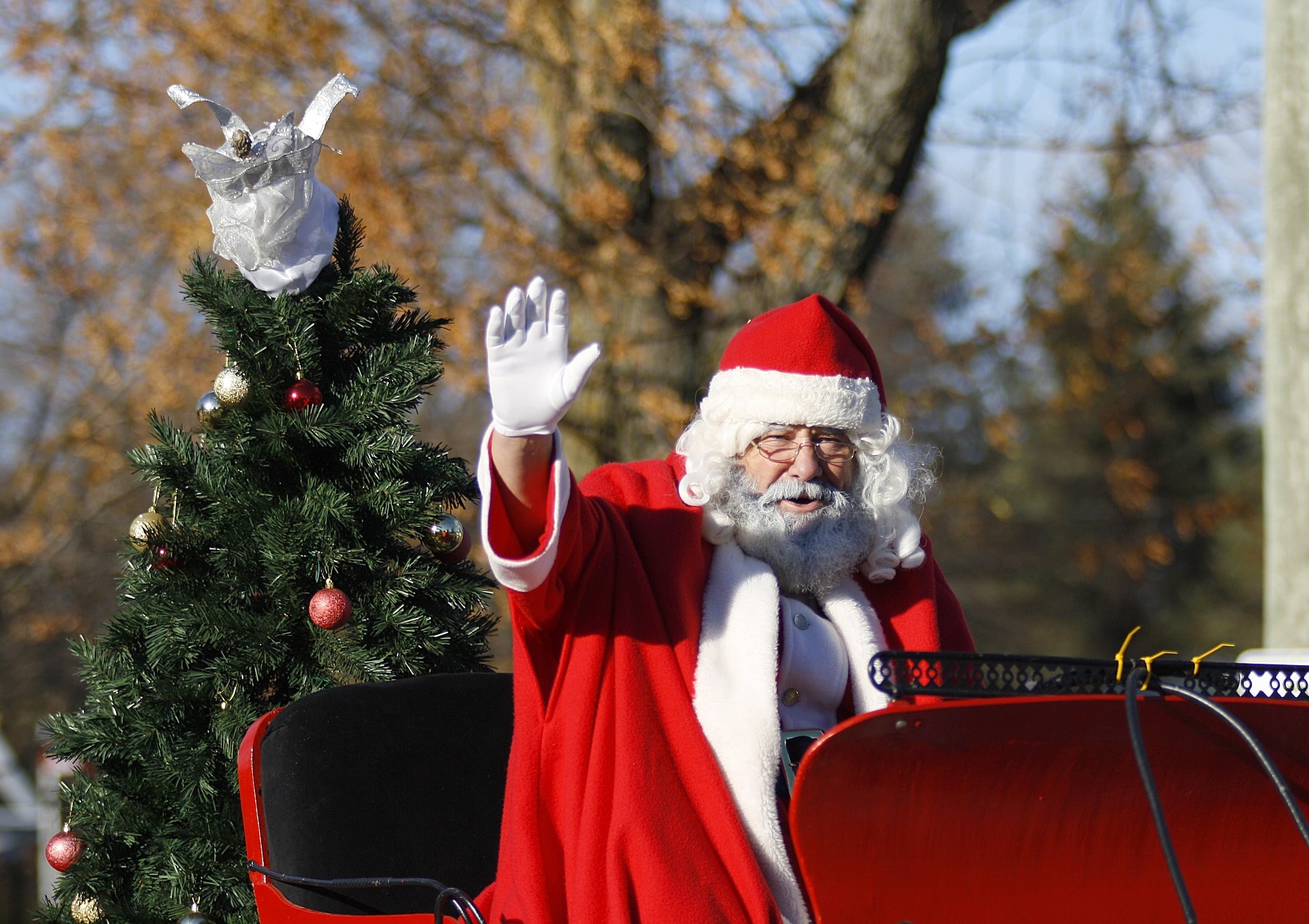 santa waving on sleigh in parade